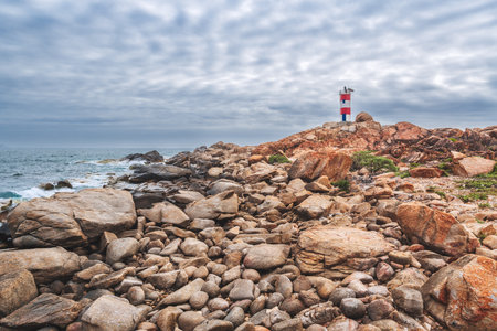 Landscape view of the red and white lighthouse Hai Dang Ganh Dang on the edge of a cliff by the sea in Phuyen Province, Vietnamの写真素材