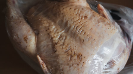 Fresh chicken with golden skin, ready for sale, close-upの写真素材