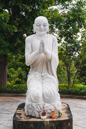 Majestic view of white Buddha statue among foliage of green trees at the Linh Ung Pagodaの写真素材