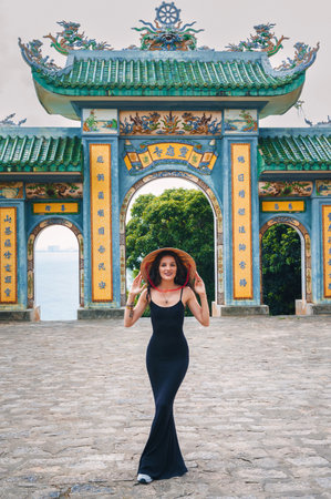 Woman traveler visiting at Linh Ung Pagoda temple, translation from Chinese character. Tourist with Vietnamese hat traveling in Da Nang city.の写真素材