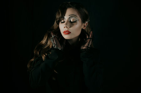 Portrait of a young woman in a Gothic gloomy image of a witch or vampire. Halloween costume.の写真素材