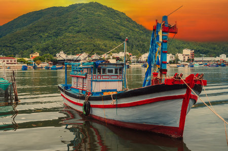 View of traditional Vietnamese fishing boats, ships and vessels at the fishing seaport by the sea in Nha Trang.の写真素材