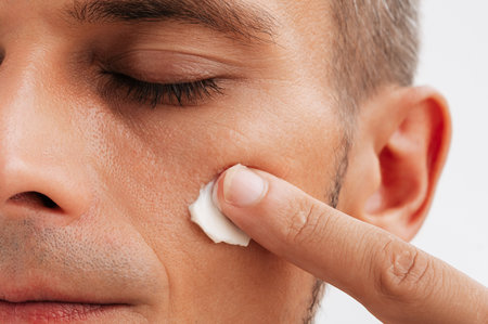 close-up of a man using a facial moisturizer.の写真素材