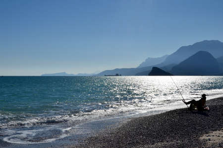 Fisherman fishing in the sea at sunsetの写真素材