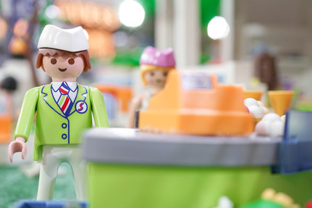BANGKOK - MAY 6, 2016 : Portrait shot of Playmobil Shop assistant in green uniform standing behind the cashier. Customer service. Playmobil belongs to a toy company, the Brandstatter Group, in Germanyのeditorial素材