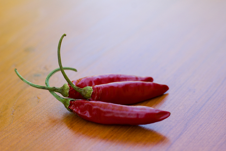 Chili peppers on wooden tableの写真素材