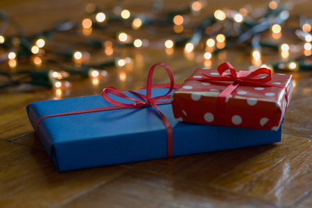 Christmas gifts and decorations with christmas lights as background, gift boxes with ribbonの写真素材