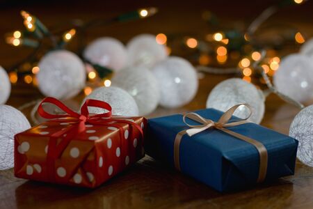 Christmas gifts and decorations with christmas lights as background, gift boxes with ribbon
