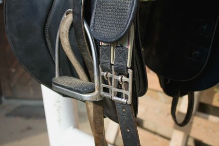 Black leather on a barrier in the stable, and Stirrup buckle in detailの写真素材