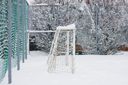 public playground in winter, snowy football field for childrenの写真素材