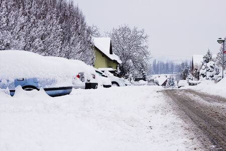 Winter snow Calamity in a city, snow covered cars at a car park. Snowy streetの写真素材