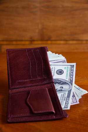 leather wallet full of dollar bills on the table, US banknotes