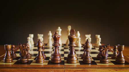 chessboard with wooden figures, black chess figures on foreground, chess with a dark color gradient backgroundの写真素材