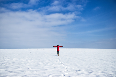 Young woman enjoying from beautiful weather in winter landscape. Female hiker with outstretched arms. Happy girl on winter holidays. の写真素材