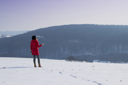 Woman is enjoying sunny winter day. Woman smoking a cigarette in beautiful snowy landscape.の写真素材