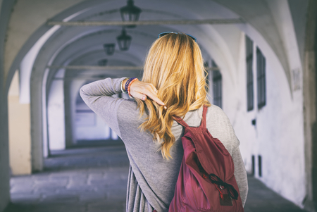 Woman traveler walking through arcade in european historic city, tourist girl discover beauty of Europeの写真素材