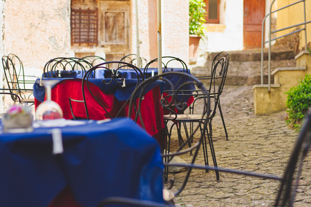 Set tables in a street restaurant at Sardegna, Italy, outdoor cafe terrace in european cityの写真素材