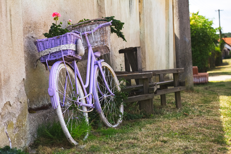 Retro bicycle with wicker baskets as a decoration next to wall. Vintage bike with flower.の写真素材
