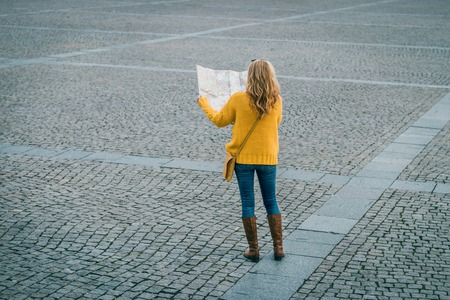 Tourist lost in the city. Woman looking to the city map and trying find the way. Travel conceptの写真素材