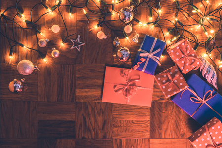 Christmas decoration with gift boxes, jingle bells and christmas lights. Merry christmas greeting cardの写真素材