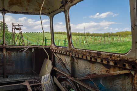 View of a rusty old bus on a spring landscape with lookout tower. Environmental damage.の写真素材