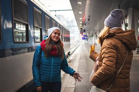 I miss you already! Two women friends say goodbye at the train station before travel. Travel concept with two persons. Railway transportationの写真素材