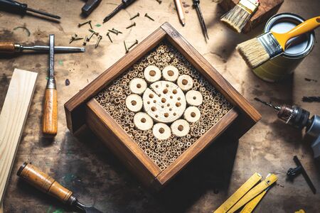 Insect hotel or house on wooden table at workshop. Homemade craft product. DIY conceptの写真素材