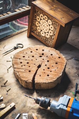Making insect hotel or house in workshop. Wooden homemade craft product and work tools on table. DIY conceptの写真素材