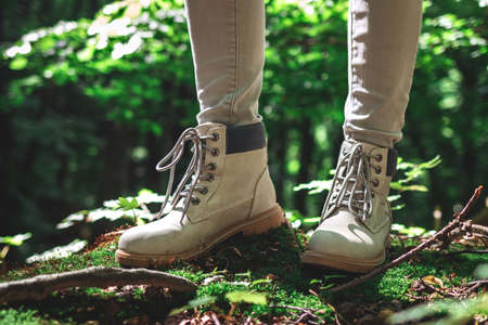 Hiker standing in forest. Tourist wearing hiking boot. Leather waterproof shoes in nature