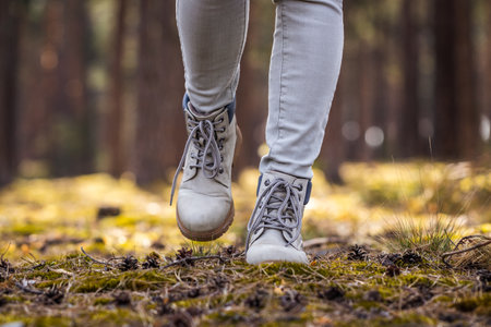 Hiking boots. Hiker walking in woodland. Female legs wearing leather sports shoes in forestの写真素材