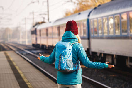Confused tourist standing at wrong railway station platform. Disappointment during traveling. Woman with backpack looking at leaving train. Solo travelerの写真素材