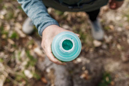 Woman drinking water from bottle. Resting during hiking in forest. Top view. Fitness and sport activityの写真素材