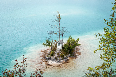 Small island with Ochsenkreuz chapel in Wolfgangsee lake. Tourist attraction near Sankt Gilgen town, Salzkammergut, Austriaの写真素材
