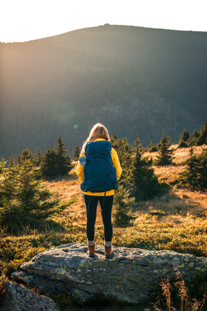 Long journey uphill. Hiking in the mountains. Woman with backpack trekking in Jeseniky mountainsの写真素材