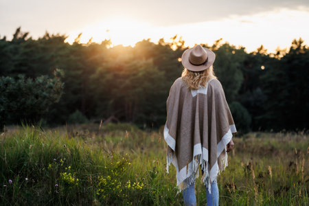 Woman relaxing in nature during sunset for good mental health and her own well-beingの写真素材