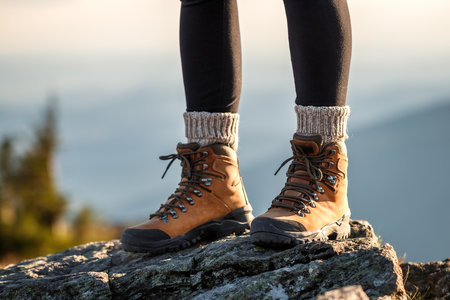 Hiking boot. Female legs on mountain summit during trekking outdoorsの写真素材