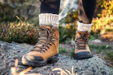 Hiking boot and alpaca sock. Legs with ankle boots on mountain trekking trailの写真素材