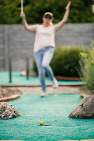 Woman missed shot during mini golf game. Summer fun and leisure activityの写真素材