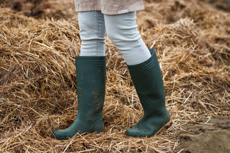 Rubber boot protective workwear. Farmer standing at organic manure agricultural fertilizerの写真素材