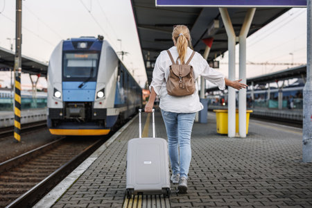 Woman traveling by train. Female tourist with suitcase in hurry at railroad station platform. Travel lifestyleの写真素材