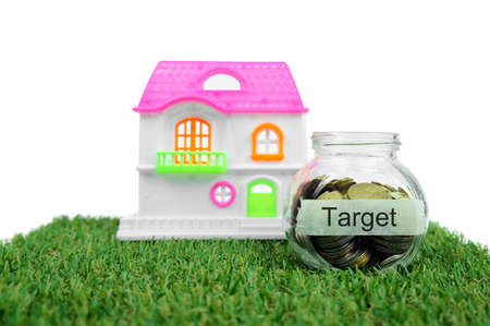 Coins in small container and house toy with label Targetの写真素材