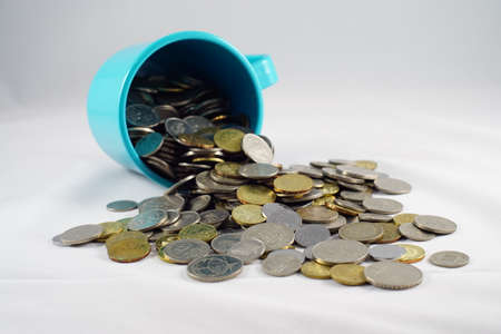 Cup of Malaysian coins spilled on a white backgroundの写真素材