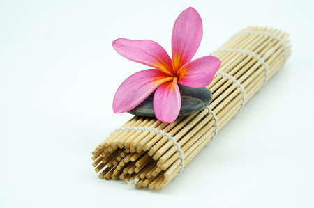 Pink Frangipani on pebble and bamboo mat isoalted on white backgroundの写真素材