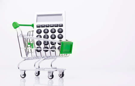 Calculator and shopping trolley over white backgroundの写真素材