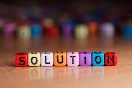 Solution words with dices on wooden table