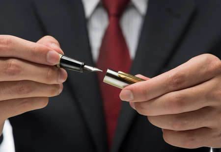 Close up image of executive holding pen