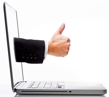 Computer Savvy Concept-Thumb up hand from inside of Laptop Screenの写真素材