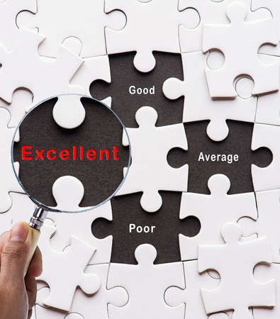 Magnifying glass searching missing puzzle peace "Excellent"の写真素材