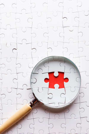 Magnifying glass searching missing puzzle peaceの写真素材