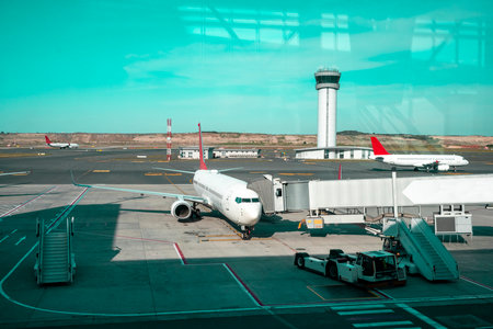Airplane, view from airport terminal. Airplane waiting to pick up passengers on the airport bridgeの写真素材